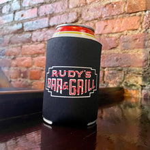 Load image into Gallery viewer, Rudy’s Bar &amp; Grill neon sign collapsible koozie with beer can on wood bar and exposed brick wall – NYC dive bar merchandise