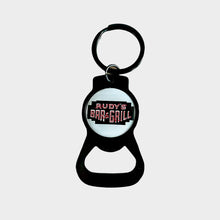 Load image into Gallery viewer, Close-up of Rudy’s Bar &amp; Grill keychain bottle opener highlighting the classic logo and metal finish