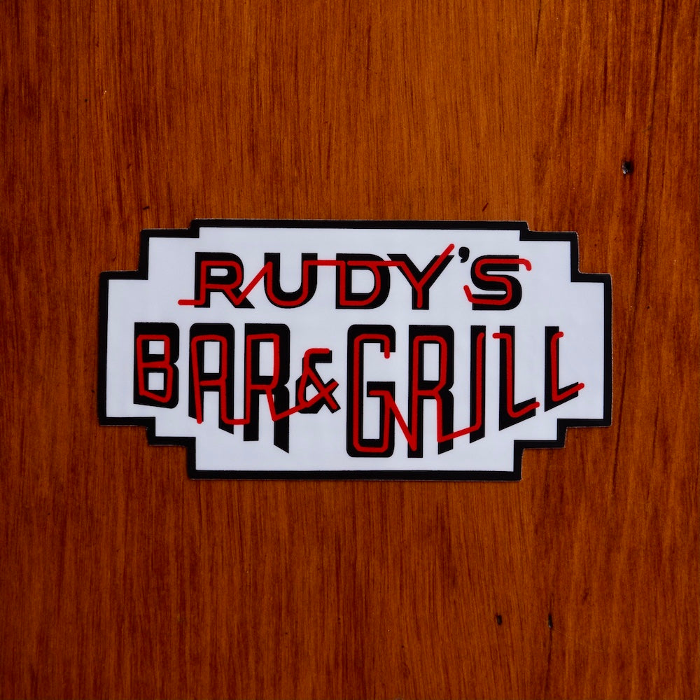 Rudy’s Bar & Grill neon sign logo sticker on wood background in Hell’s Kitchen bar